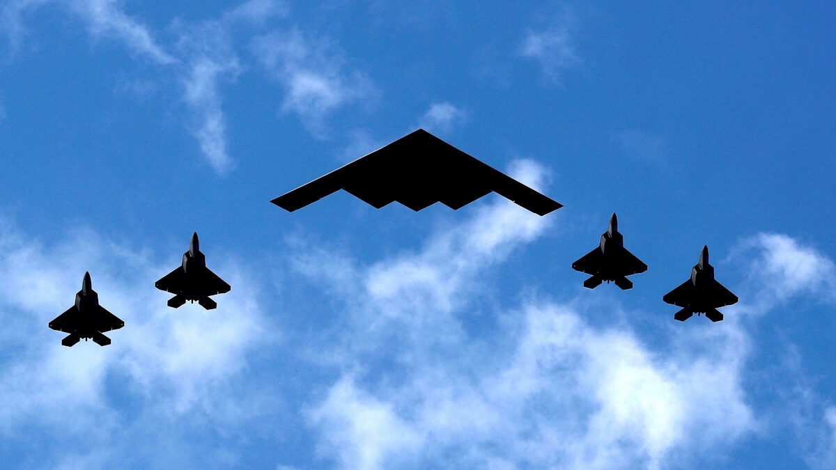 Ένα βομβαρδιστικό B-2 Spirit Stealth της Πολεμικής Αεροπορίας των ΗΠΑ πλαισιώνεται από τέσσερα μαχητικά αεροσκάφη F-22 Raptor