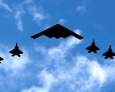 Ένα βομβαρδιστικό B-2 Spirit Stealth της Πολεμικής Αεροπορίας των ΗΠΑ πλαισιώνεται από τέσσερα μαχητικά αεροσκάφη F-22 Raptor