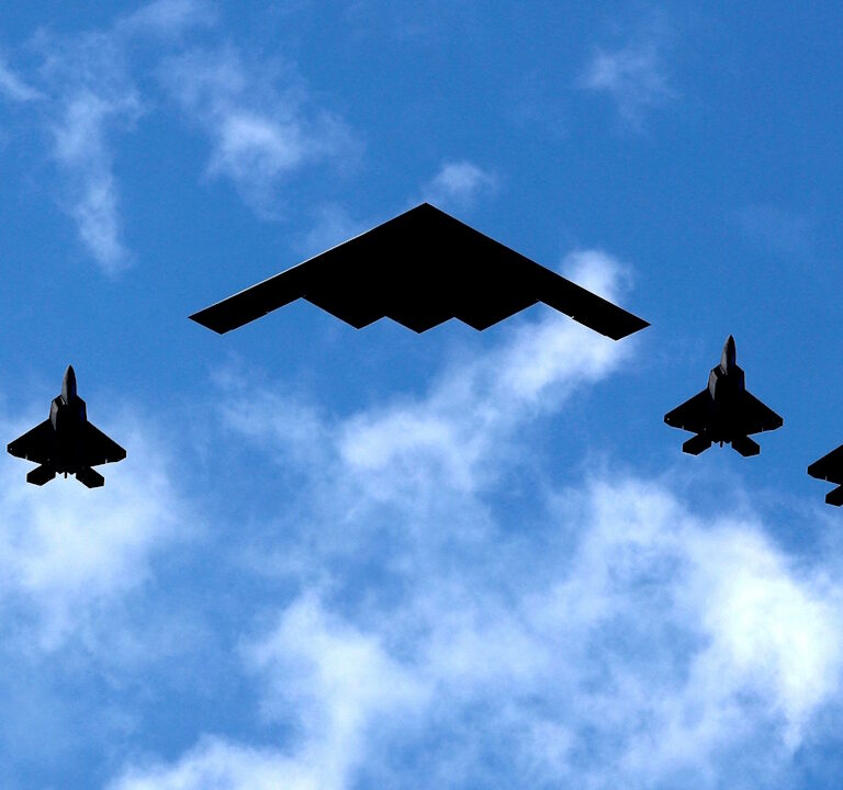 Ένα βομβαρδιστικό B-2 Spirit Stealth της Πολεμικής Αεροπορίας των ΗΠΑ πλαισιώνεται από τέσσερα μαχητικά αεροσκάφη F-22 Raptor