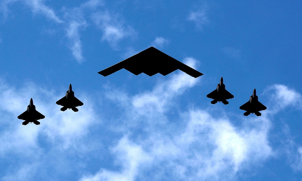 Ένα βομβαρδιστικό B-2 Spirit Stealth της Πολεμικής Αεροπορίας των ΗΠΑ πλαισιώνεται από τέσσερα μαχητικά αεροσκάφη F-22 Raptor