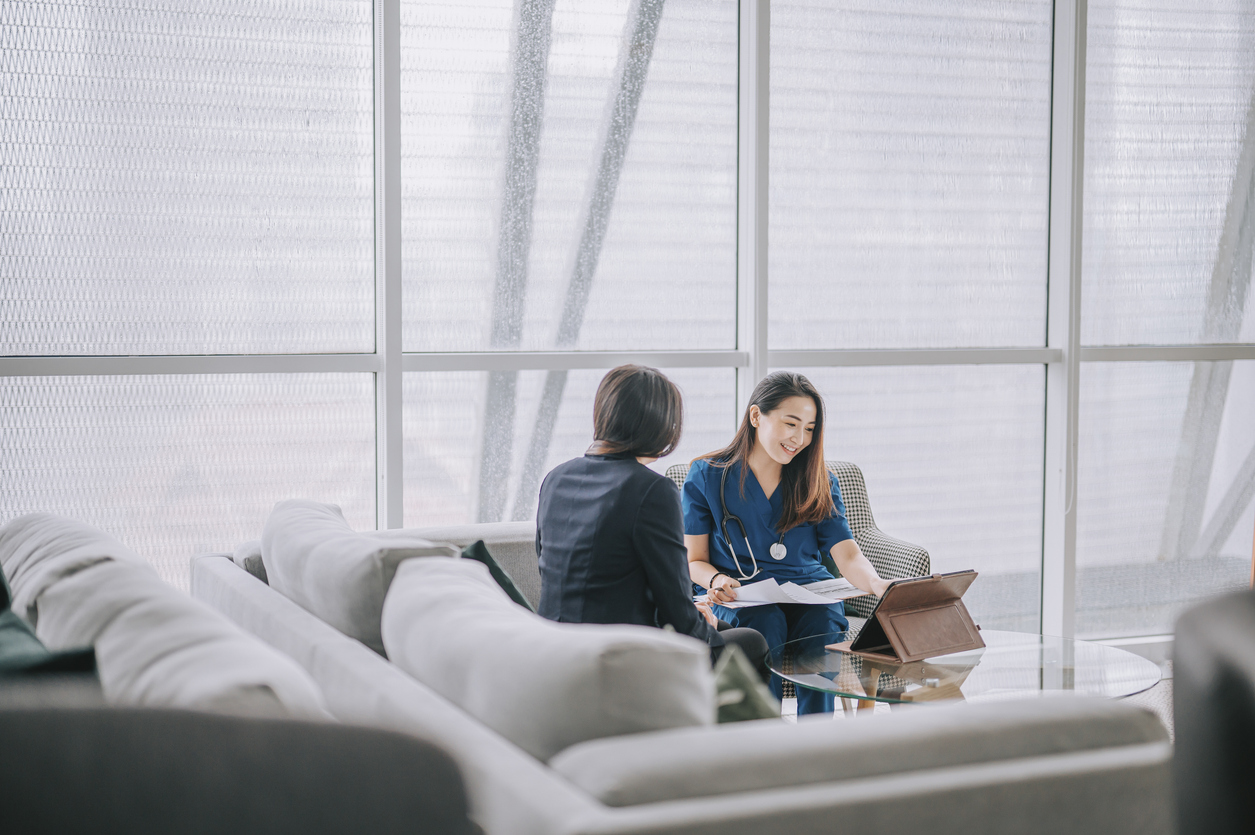 Asian chinese female doctor explaining medical report To a female Patient at her office sofa