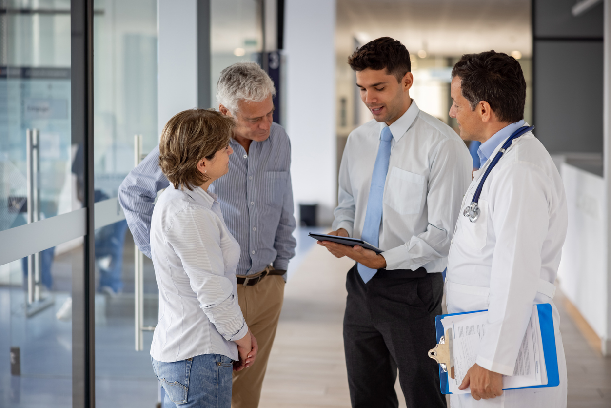 Latin American patients talking to the hospital manager and a doctor about their health insurance coverage