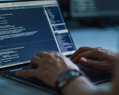 Close-up Focus on Person's Hands Typing on the Desktop Computer Keyboard. Screens Show Coding Language User Interface. Software Engineer Create Innovative e-Commerce App. Program Development