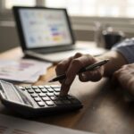 Business accounting concept, Business man using calculator with computer laptop, budget and loan paper in office.