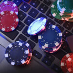 Online game betting concept with chips on laptop keyboard and bank card. Top view.