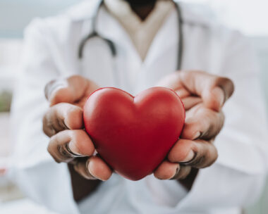 Portrait of a doctor holding a heart in his hands