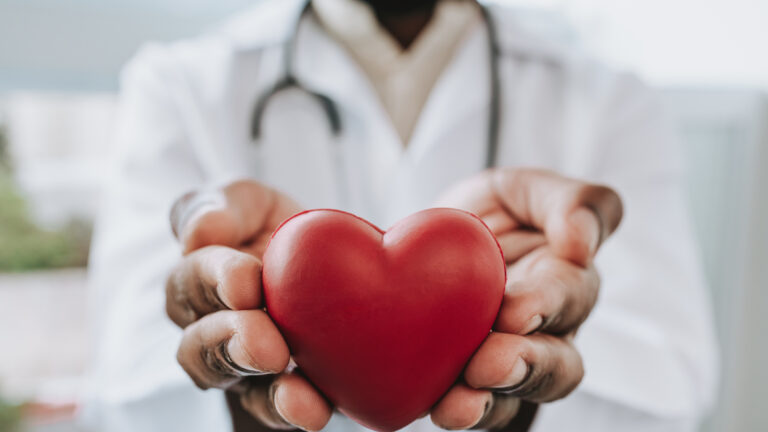 Portrait of a doctor holding a heart in his hands
