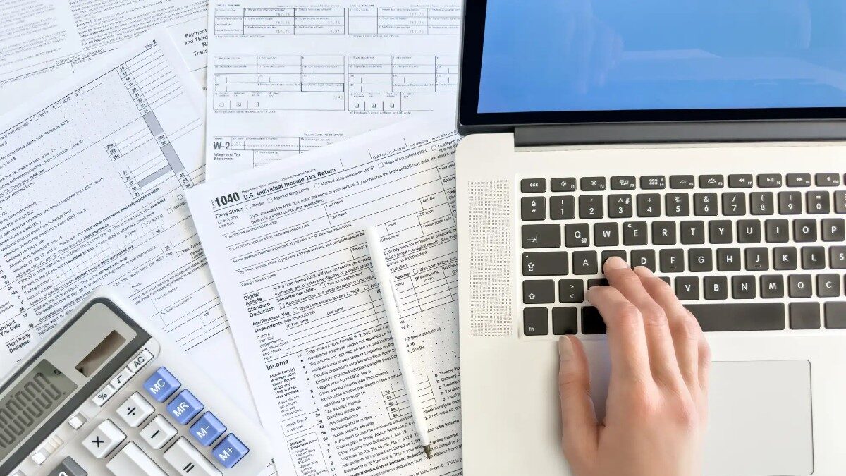 Doing taxes with laptop and tax forms in a house