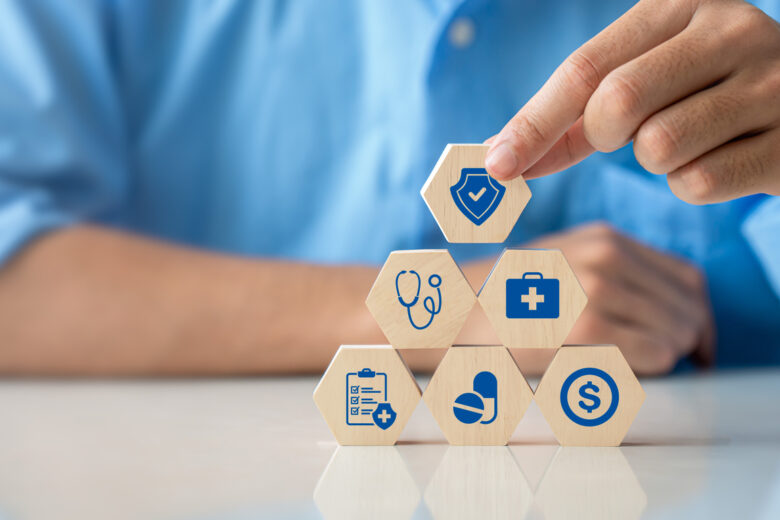 Health insurance concept. Hand holding wooden cube with healthcare medical icon. Family life insurance and policy concepts, hospital, medical treatment. copy space.