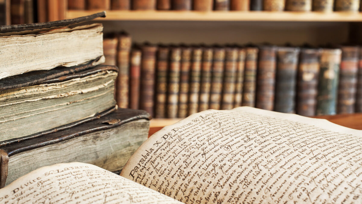 Opened vintage book in a library. 400 year old handwrite