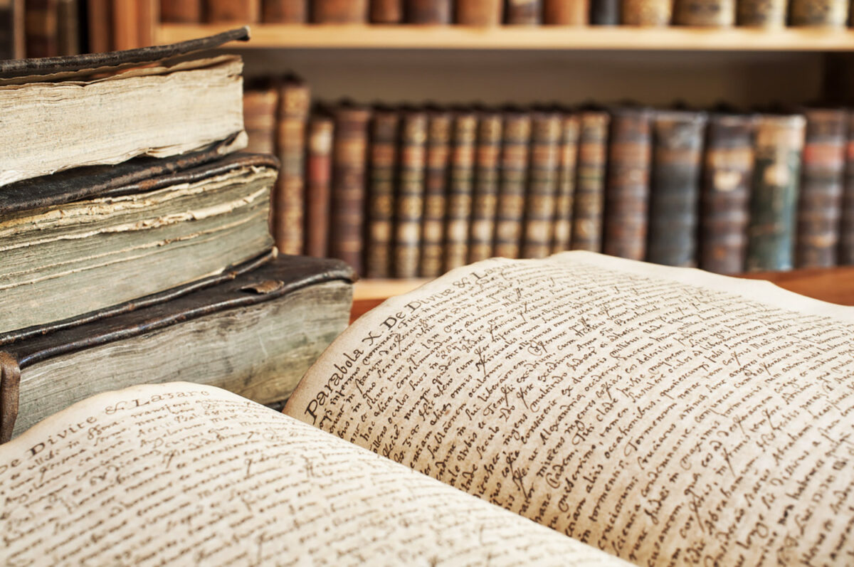 Opened vintage book in a library. 400 year old handwrite