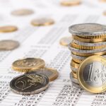 finance business accounting stock background with stack of euro coins on data sheet