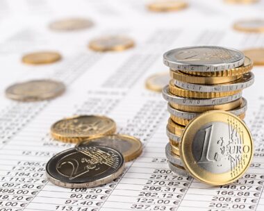 finance business accounting stock background with stack of euro coins on data sheet