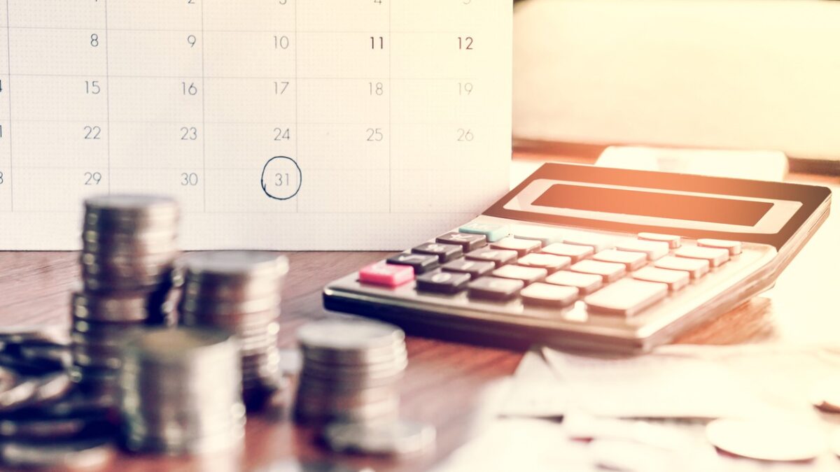 debt collection and tax season concept with deadline calendar remind note,coins,banks,calculator on table, background ,time to pay concept