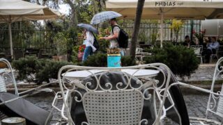 Περαστικοί με ομπρέλες στην Αθήνα