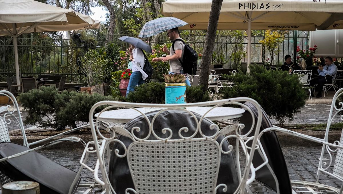 Περαστικοί με ομπρέλες στην Αθήνα