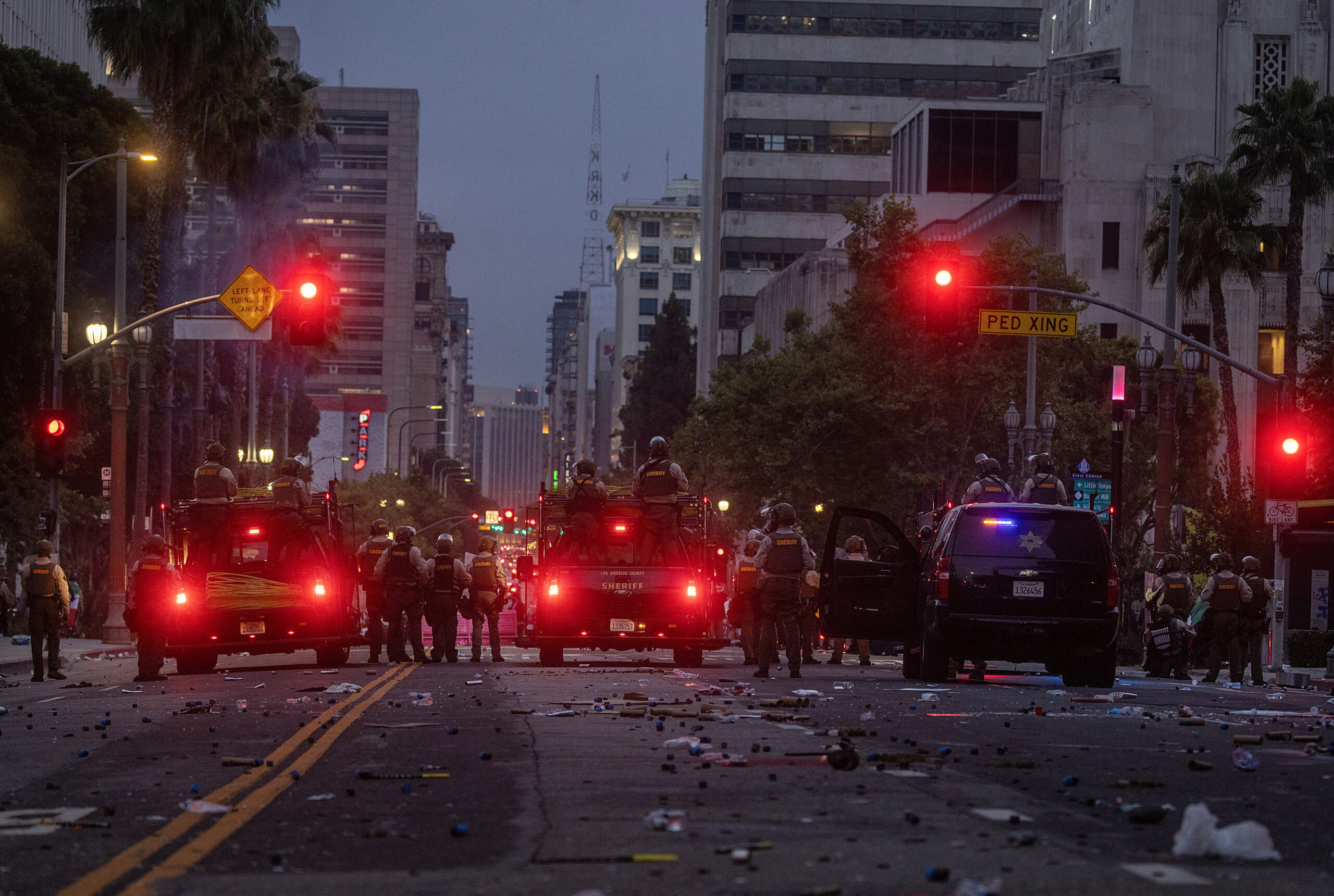Police facing protesters in the center of the burning Los Angeles