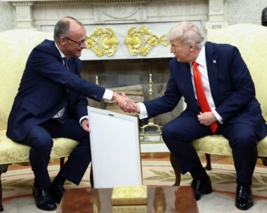 German Chancellor Friedrich Merz holds the framed birth certificate of U.S. President Donald Trump's grandfather as Merz and Trump shake hands during a meeting at the White House in Washington, D.C., U.S., June 5, 2025. REUTERS/Kevin Lamarque