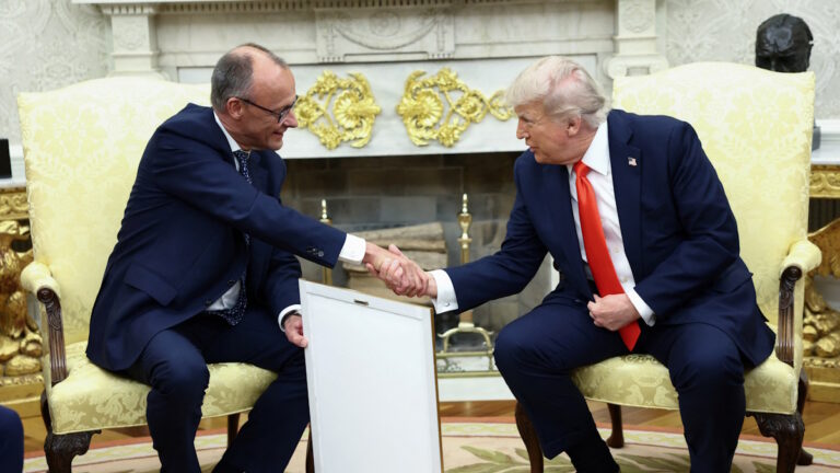 German Chancellor Friedrich Merz holds the framed birth certificate of U.S. President Donald Trump's grandfather as Merz and Trump shake hands during a meeting at the White House in Washington, D.C., U.S., June 5, 2025. REUTERS/Kevin Lamarque