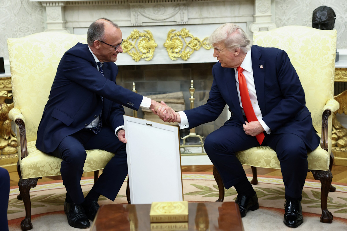 German Chancellor Friedrich Merz holds the framed birth certificate of U.S. President Donald Trump's grandfather as Merz and Trump shake hands during a meeting at the White House in Washington, D.C., U.S., June 5, 2025. REUTERS/Kevin Lamarque