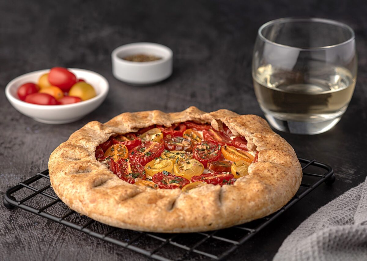 Food photography of galette with tomatoes and ricotta; white wine, seasoning, whole wheat flour; savoury pastry, shortcrust pastry