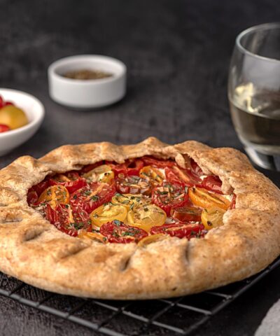 Food photography of galette with tomatoes and ricotta; white wine, seasoning, whole wheat flour; savoury pastry, shortcrust pastry