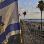 Η ισραηλινή σημαία με μια κίτρινη κορδέλα κυματίζει κατά μήκος της παραλιακής οδού του Τελ Αβίβ, Ισραήλ, Τρίτη, 24 Ιουνίου 2025