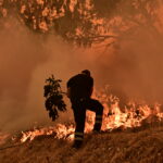 Πυροσβέστης προσπαθεί να σβήσει φωτιά