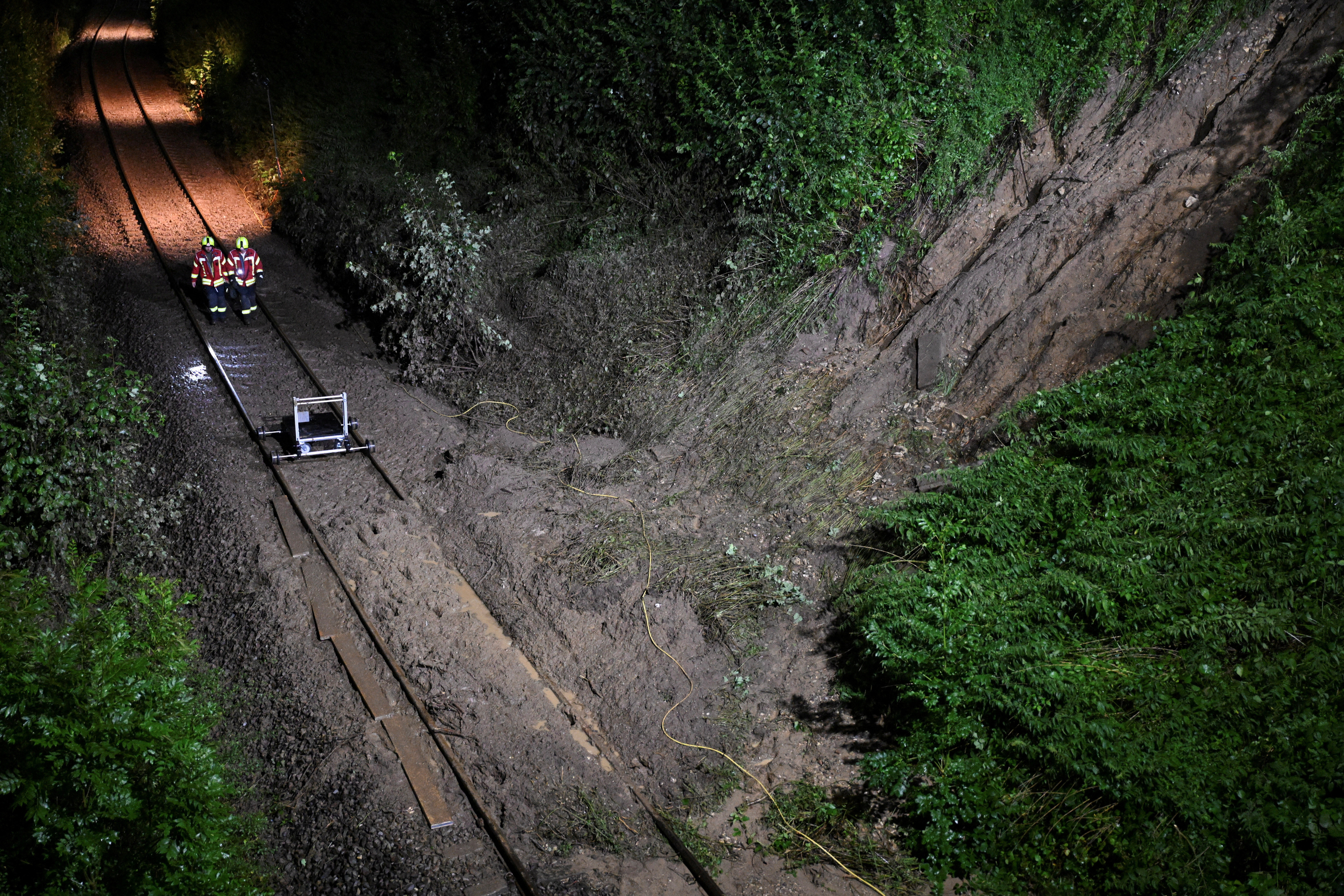 Landscreen after heavy rainfall is distinguished next to the rails, at the point where local train derails in Germany