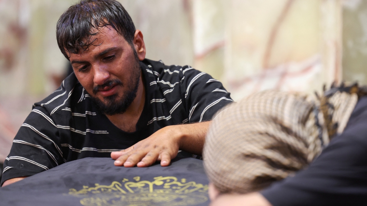 Man caresses the coffin of his beloved
