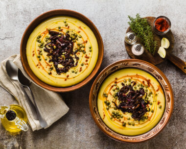 Authentic Greek Fava recipe, Middle Eastern yellow lentil soup with caramelized onions, paprika and capers. vegan healthy food in clay pots on the stone table
