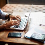 Senior businessman typing on a laptop in a coworking space