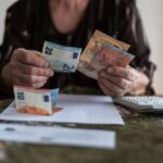 Senior woman is calculating taxes at home.Counts the pension.