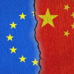European Union flag and Chinese flag painted on cracked wall
