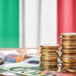 Euro banknotes and coins in front of the national flag of Italy