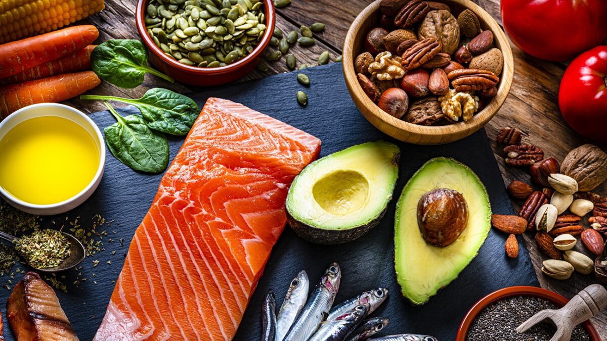 Healthy eating: high angle view of a group of food with high levels of Omega-3 fat. The composition includes salmon, sardines, avocado, extra virgin olive oil, and various nuts and seeds like pumpkin seeds, chis seeds, pecan, almonds, pistachio, walnuts and hazelnuts. High resolution 42Mp studio digital capture taken with Sony A7rII and Sony FE 90mm f2.8 macro G OSS lens