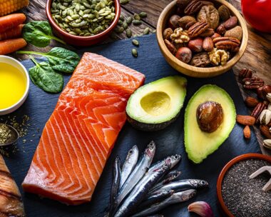 Healthy eating: high angle view of a group of food with high levels of Omega-3 fat. The composition includes salmon, sardines, avocado, extra virgin olive oil, and various nuts and seeds like pumpkin seeds, chis seeds, pecan, almonds, pistachio, walnuts and hazelnuts. High resolution 42Mp studio digital capture taken with Sony A7rII and Sony FE 90mm f2.8 macro G OSS lens