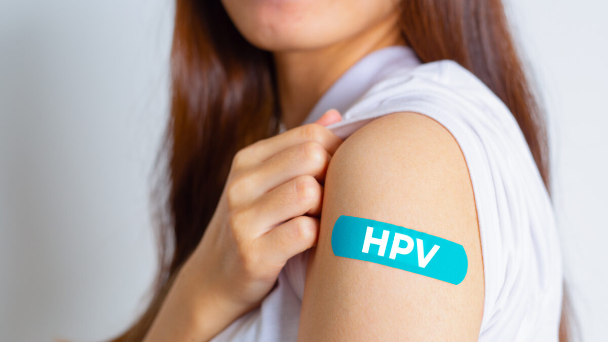 HPV (Human Papillomavirus) Teenager woman showing off an blue bandage after receiving the HPV vaccine. viruses Some strains infect genitals and can cause cervical cancer