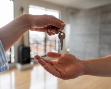 Close-up on a real estate agent giving the keys of his new house to a man - home ownership concepts