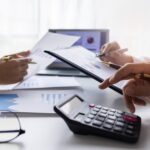 Team of Business people working at workplace with tablet and document, doing planning analyzing Tax financial report, business plan investment, finance analysis Economic business discussions.