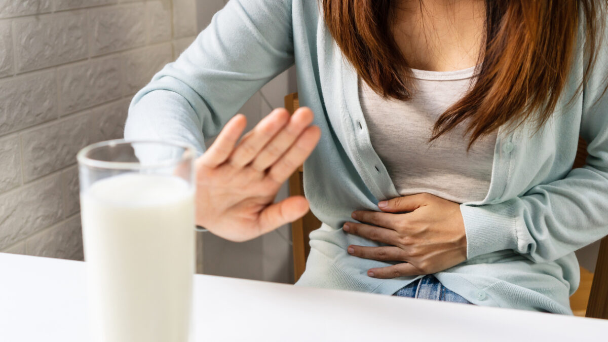 Female gesturing stop or say no to drink milk. Lactose intolerance, food allergy concept