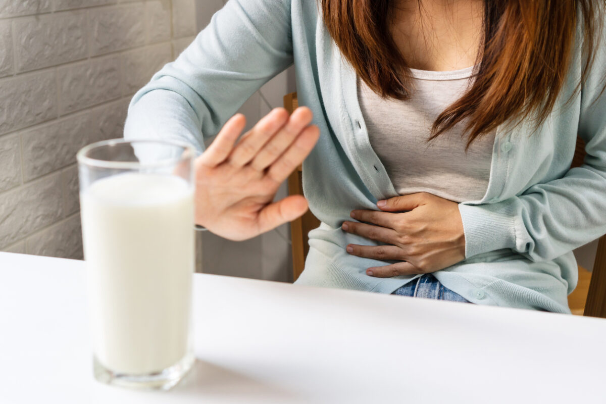 Female gesturing stop or say no to drink milk. Lactose intolerance, food allergy concept