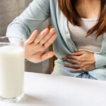 Female gesturing stop or say no to drink milk. Lactose intolerance, food allergy concept