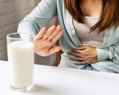 Female gesturing stop or say no to drink milk. Lactose intolerance, food allergy concept