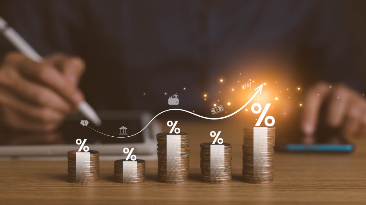 interest rates and dividends, investment returns, income, retirement Compensation fund, investment, dividend tax. pile of coins and upward direction percentage symbol. saving money for investment