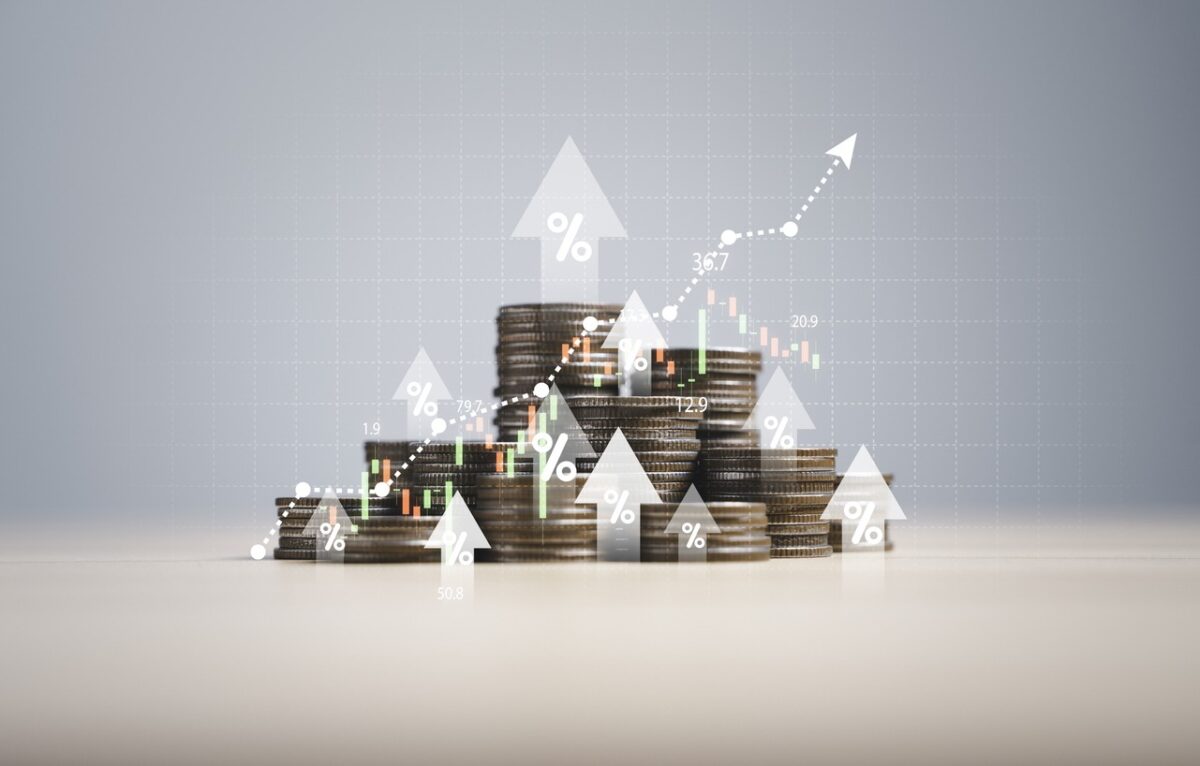 Heap of coins money with up arrow and stock market chart for financial banking increase interest rate or mortgage investment dividend from business growth concept.