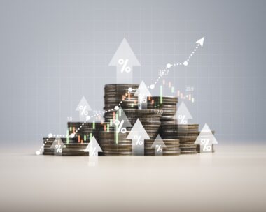 Heap of coins money with up arrow and stock market chart for financial banking increase interest rate or mortgage investment dividend from business growth concept.