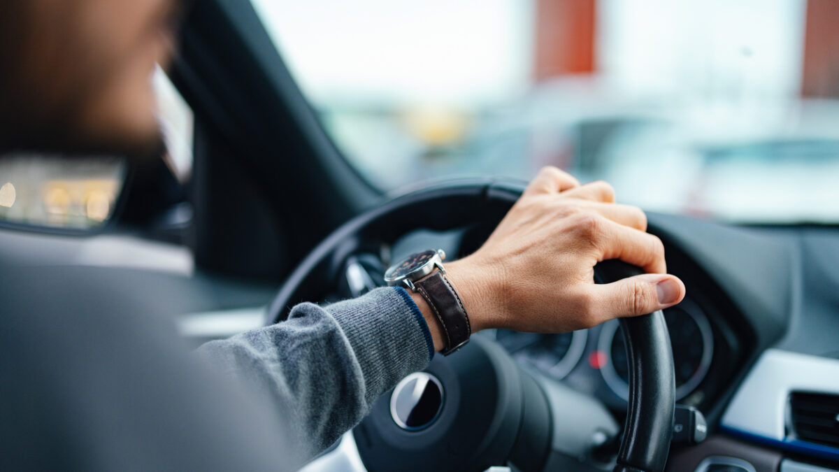 A close up view of an unrecognizable Caucasian male working as a taxi driver.