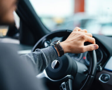 A close up view of an unrecognizable Caucasian male working as a taxi driver.
