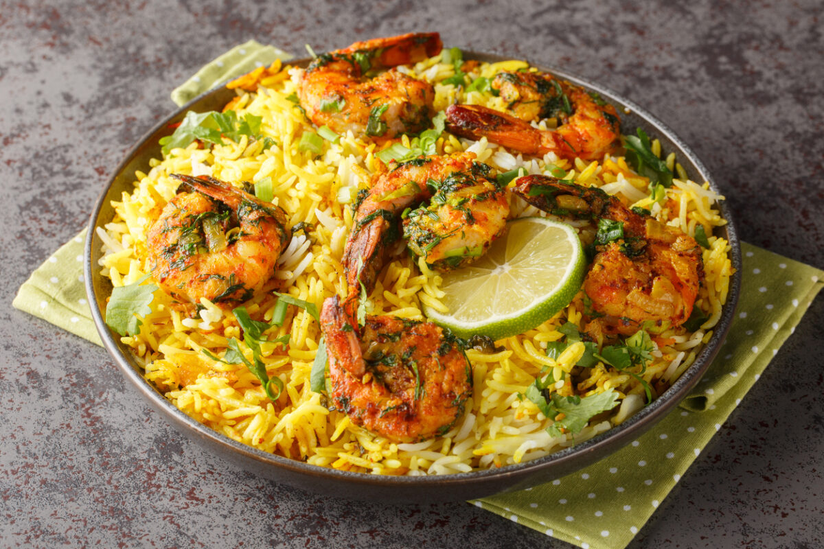 Popular Iranian seafood pilaf Meygoo Polo with herbs and prawns closeup on the plate on the table